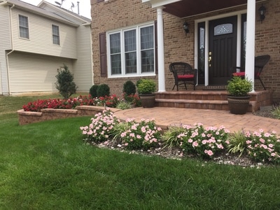 Paver walkway with paver stoop and bullnose steps.  Paver retaining walls with raised beds. 