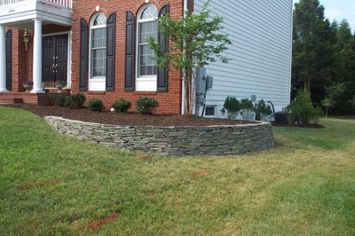 Stacked fieldstone wall with raised bed. 