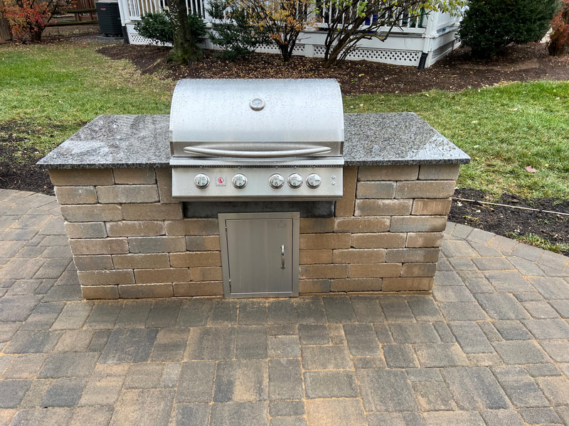 Built-in outdoor grill wallstone pavers and granite countertop. 