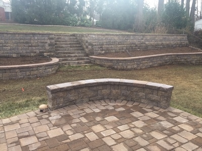 Paver patio with seating wall.  Extensive retaining wall system and raised beds. 