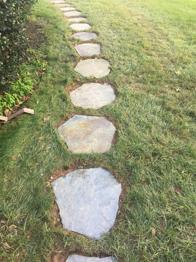 Irregular flagstone stepping stones, flush to turf. 