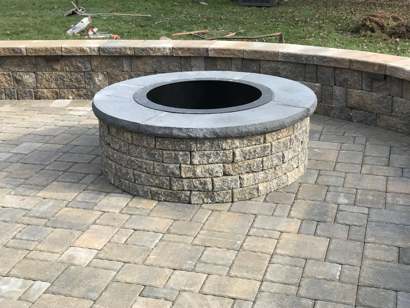 Paver patio.  Paver wallstone seating wall with capstone.  Paver permanent firepit with metal insert. 