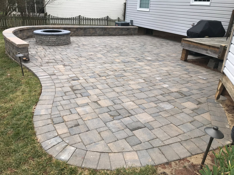Paver patio with seating wall and permanent paver firepit with metal insert. 