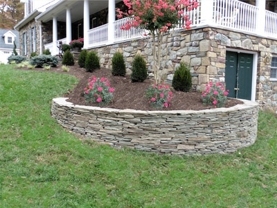Fieldstone dry-stacked retaining wall.  Raised bed. 