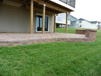 Under-deck patio with footer wall and seating wall with capstone. 