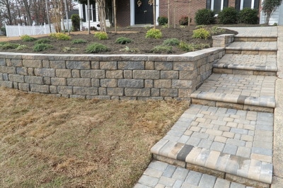 Paver steps and paver retaining wall with capstone.  Raised beds. 